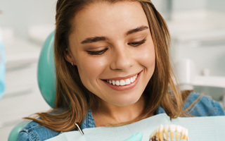Woman smiling in the dental chair after cosmetic dentistry